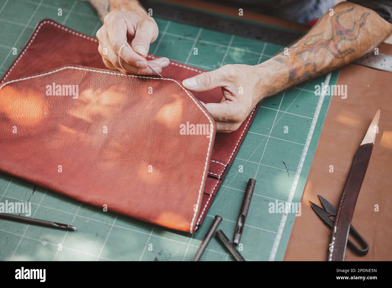 Nahthandwerker Lederhandwerker in der Lederwerkstatt. Ein Mann, der Handwerker hält und arbeitet. Er näht einen Hammer, um einen Walzer zu machen. Ta Stockfoto