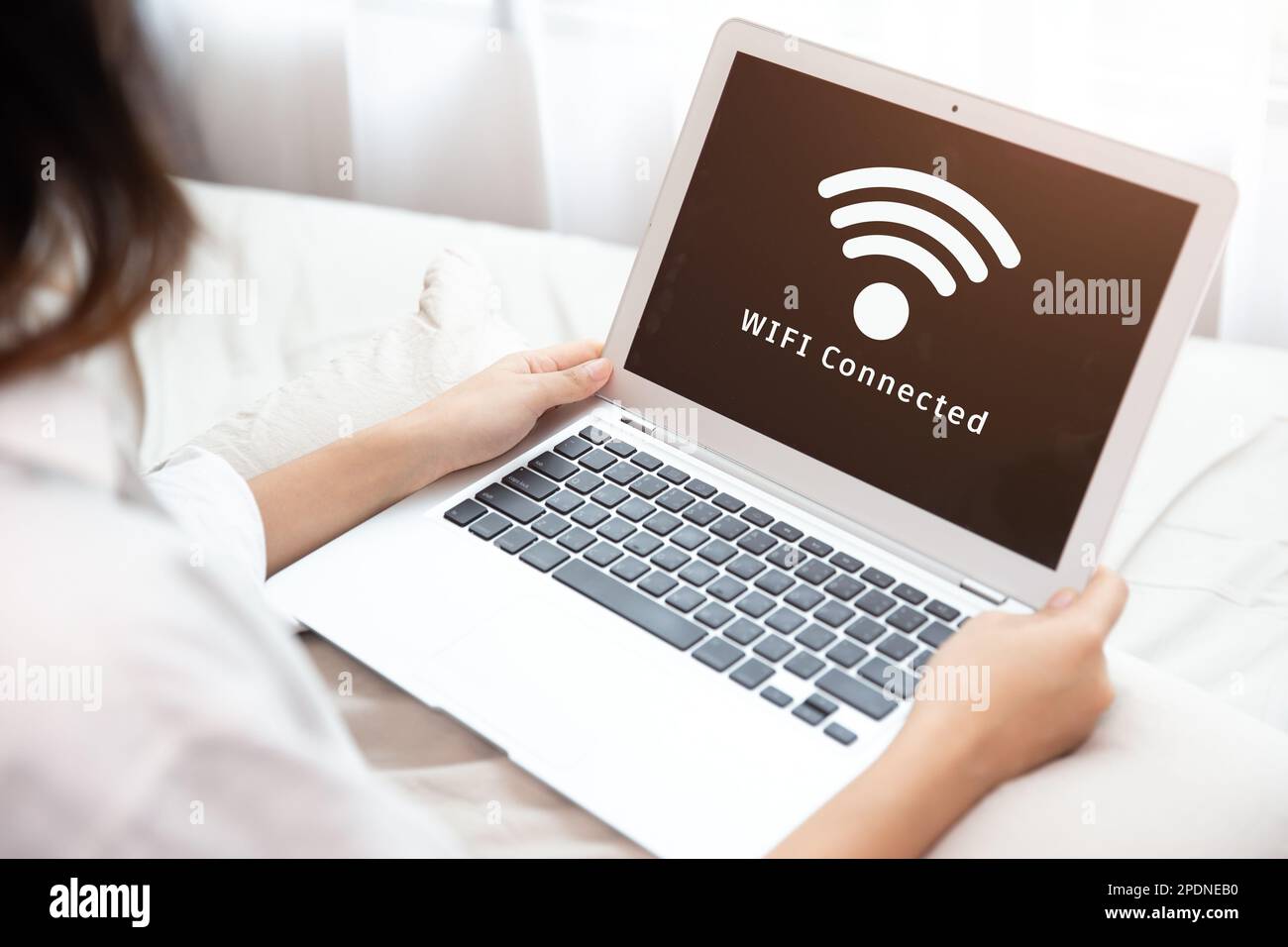 Menschen, die einen Laptop verwenden, verbinden sich mit dem Internet über das WLAN-Access-Point-Heimnetzwerksystem Stockfoto