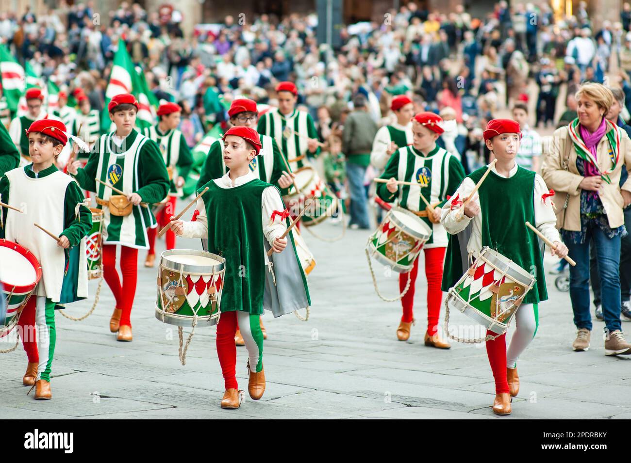 SIENA, ITALIEN - JULI 2013: Mitglieder der edlen Contrada dell'Oca tragen Fahnen mit einer gekrönten Gans auf dem Corteo Storico, einem historischen Kostümparadies Stockfoto