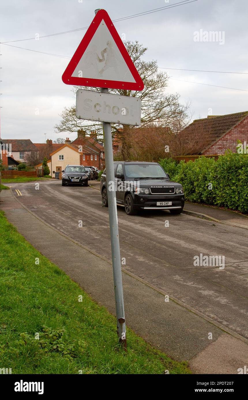 In einer ruhigen Wohnstraße in einer kleinen Marktstadt in Suffolk ist ein Schulwarnschild so verblasst, dass es nutzlos ist Stockfoto