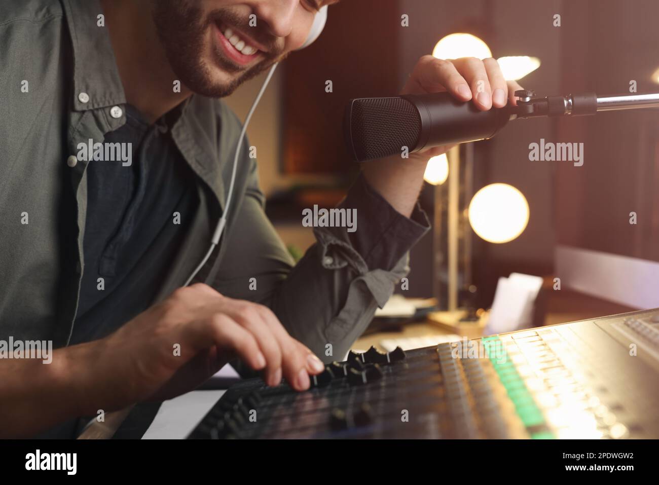 Ein Mann, der als Radio-Moderator in einem modernen Studio arbeitet, Nahaufnahme Stockfoto