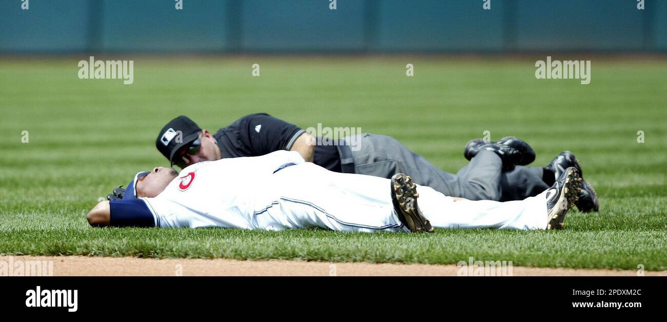 Cleveland Indians second baseman Ronnie Belliard (20) lies on the ground next to second base umpire Eric Cooper after the two collided in the sixth inning Thursday, Aug. 18, 2005, at Jacob's Field in Cleveland. Belliard left the game following the incident. (AP Photo/Scott R. Galvin) Stockfoto