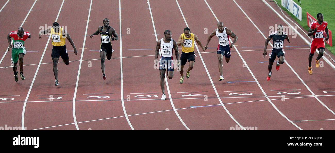 Justin Gatlin of the USA, fourth from left, crosses the finish line to