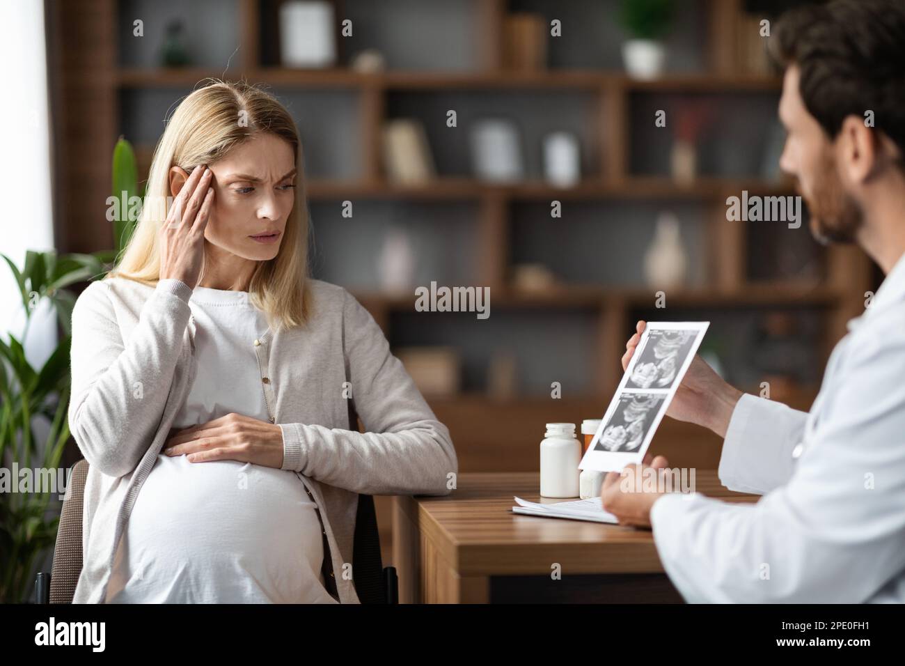 Gynäkologe Doktor Zeigt Baby-Sonograpie An Gestresste Schwangere In Der Klinik Stockfoto