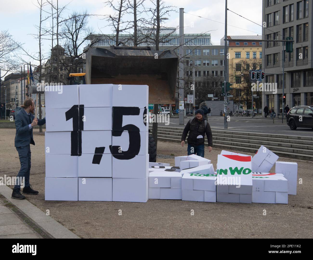 Berlin, Deutschland. 15. März 2023. Aktivisten der Umweltgruppe Robin Wood reißen mit einem Bagger eine Wand aus Pappkartons während einer Protestaktion beim Bundesministerium für Verkehr ab. Darauf stand, das 1,5-Grad-Klimaziel zu lesen. Die Protestaktion wurde durch die Präsentation der Klimabilanz 2022 ausgelöst. Kredit: Paul Zinken/dpa/Alamy Live News Stockfoto