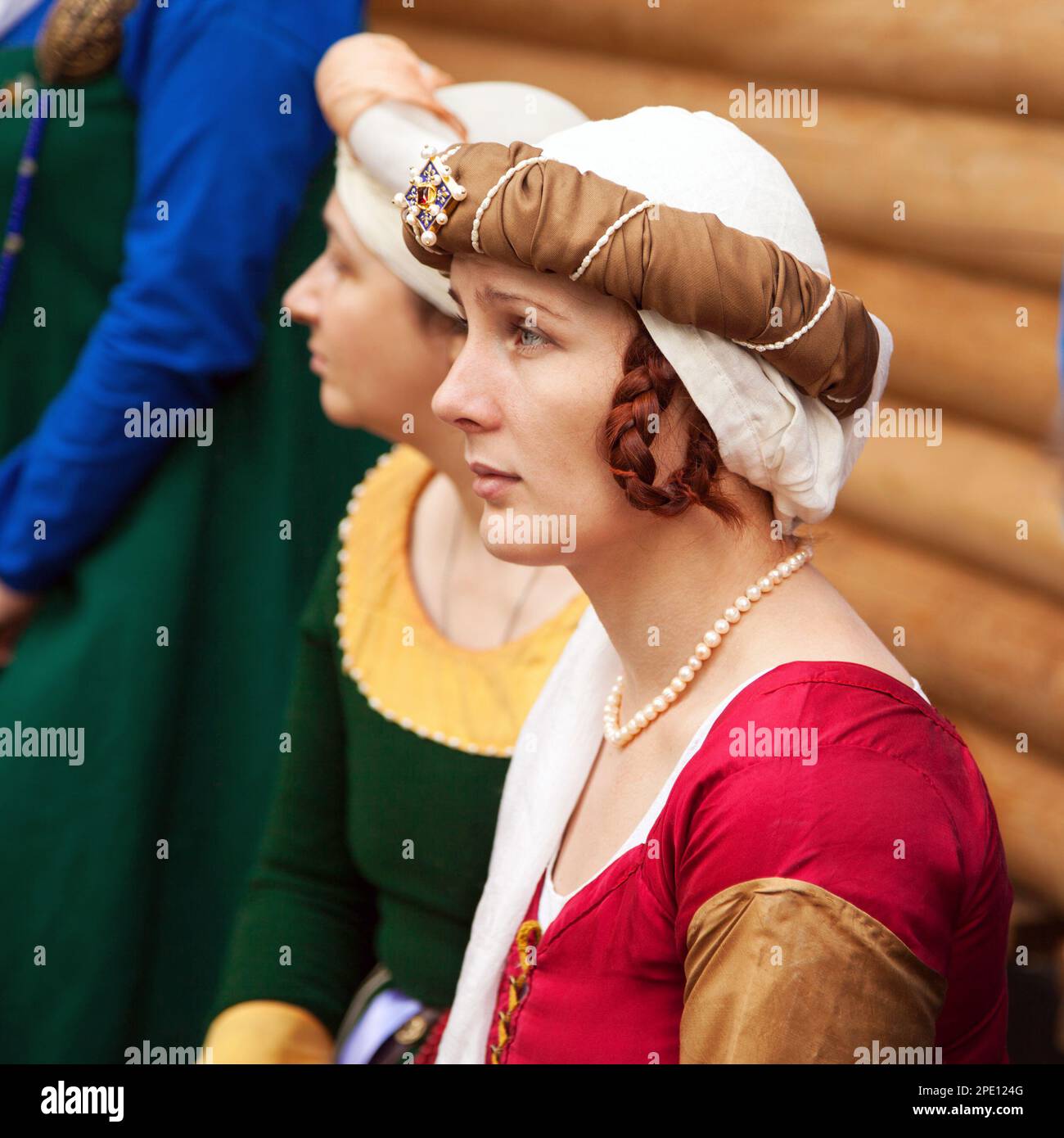 Chabarowsk, Russland - 11. Juni 2017: Mittelalter Kostümen - edle Fräulein tragen rote Kleid, eine Kopfbedeckung und Flechten Frisur. Kaukasische Frau Stockfoto