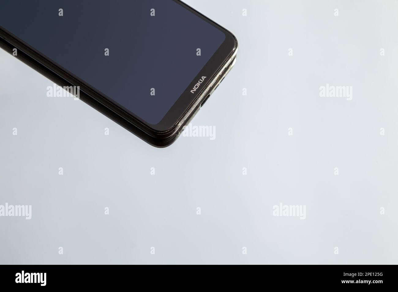 Schwarzes Smartphone Nokia 6,1 Plus auf reflektierender Oberfläche mit Kopierbereich. Modernes Mobiltelefon mit leerem Bildschirm und Firmenlogo Stockfoto