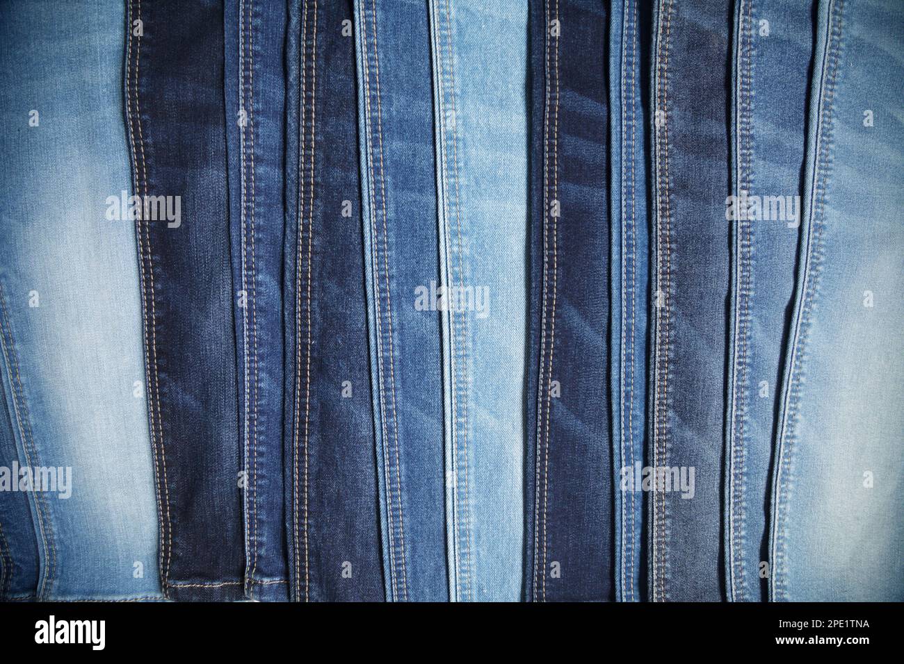 Viele blaue Jeans in einer Reihe Hintergrund angeordnet. Auswahl an lässigen Hosen in einem Bekleidungsgeschäft Stockfoto