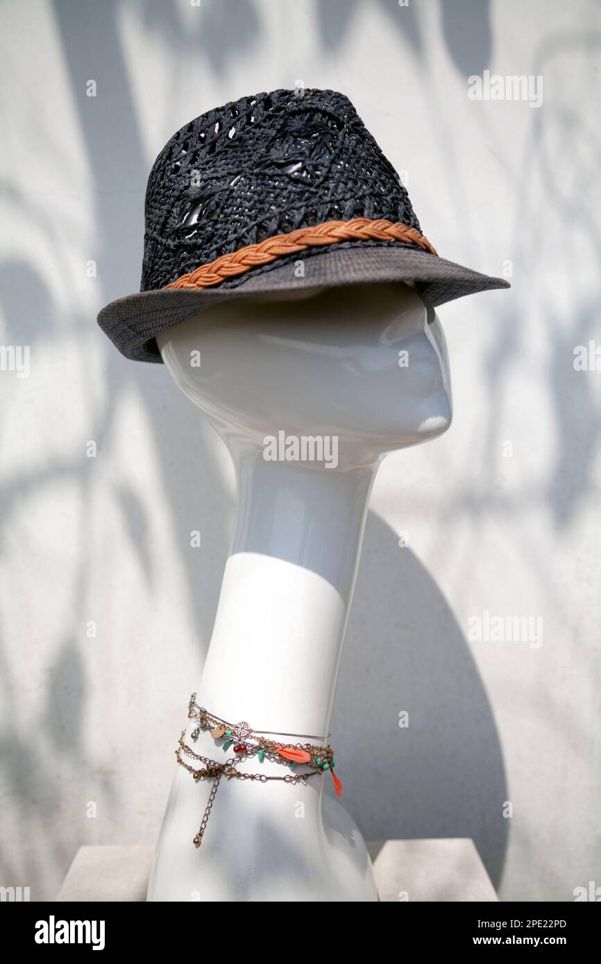 Blauer Korbhut und Schmuck auf einer Schaufensterpuppe. Elegante Schaufensterpuppe mit Modeaccessoires Stockfoto