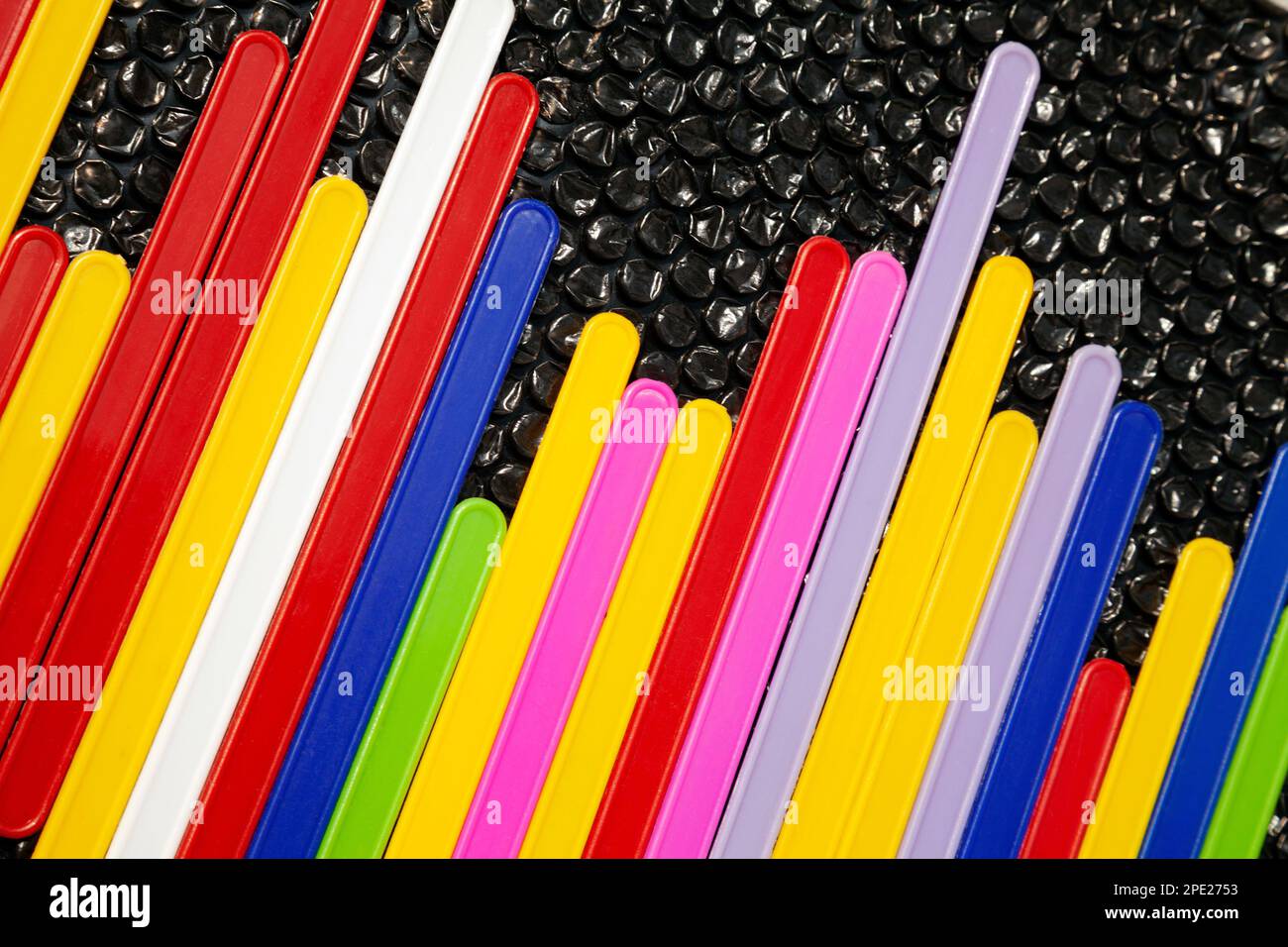Kreative Darstellung einer Equalizer-Schallwelle. Statistik in Balkendiagramm aus farbigen Kunststoffstäben auf schwarzem Hintergrund Stockfoto