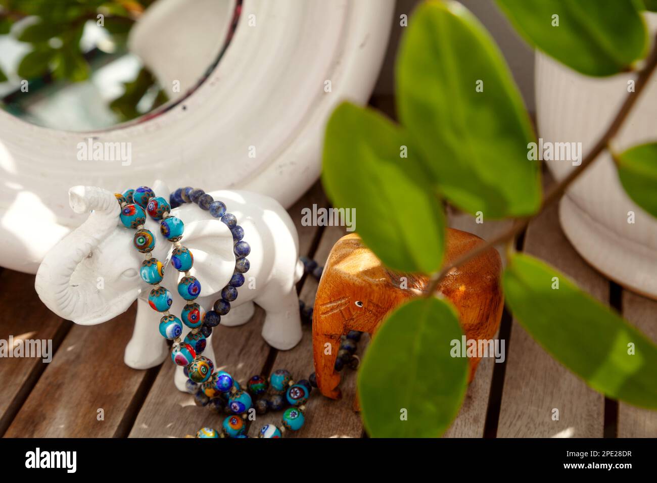 Blaues Murano-Glas und Steinperlen auf einem Frisiertisch. Schmuck auswählen, der vor einem Spiegel als Accessoire dient Stockfoto