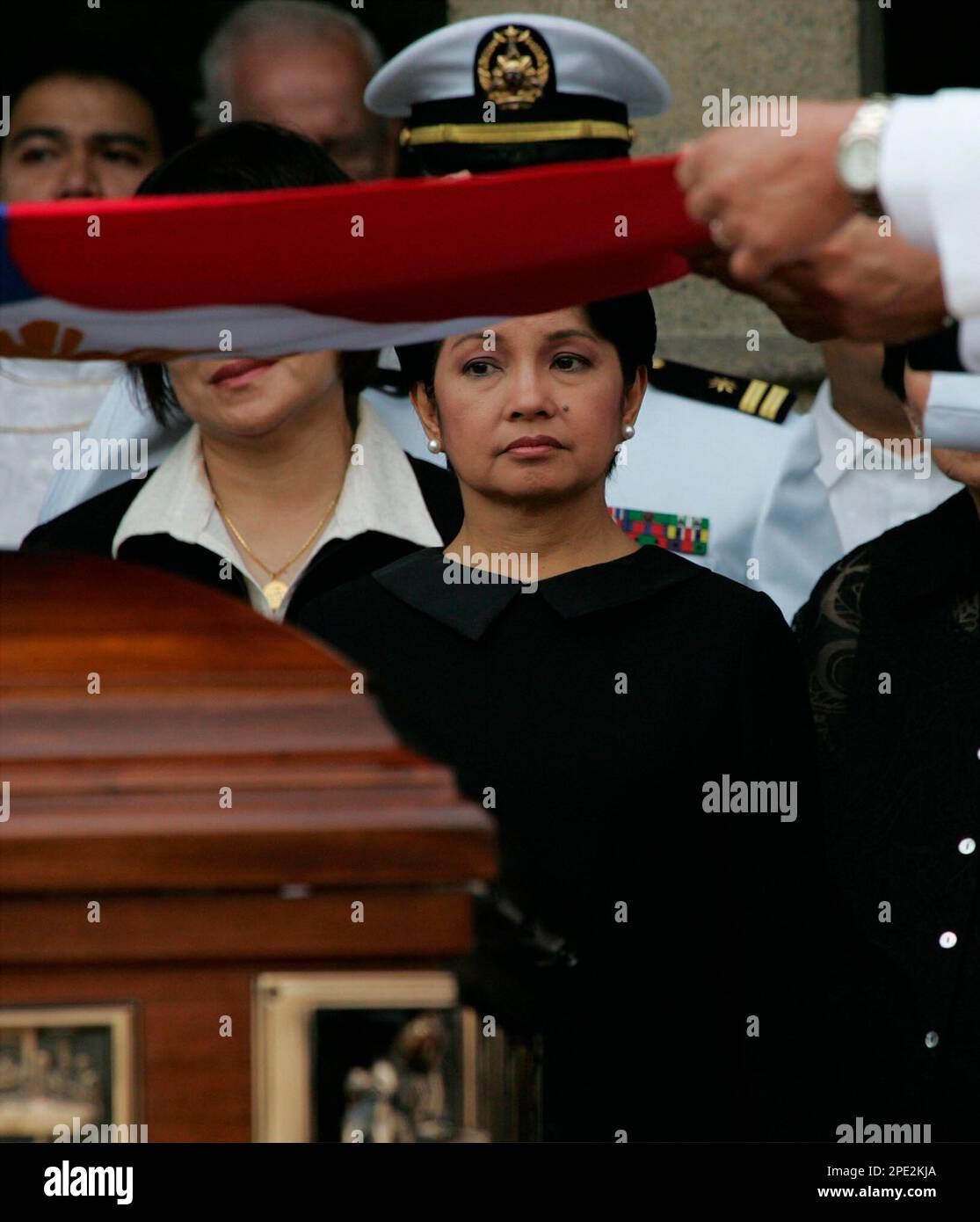 Philippine President Gloria Macapagal Arroyo, center, watches as military pallbearers fold the Philippine flag during full military honors accorded to Filipino Catholic Cardinal Jaime Sin at his funeral Tuesday, June 28, 2005. Cardinal Sin, the influential leader of the predominantly Roman Catholic Church in the Philippines who was a key figure in the "people power" revolts that ousted two presidents, died Tuesday last week after a lingering kidney ailment and diabetes. (AP Photo/Bullit Marquez) Stockfoto