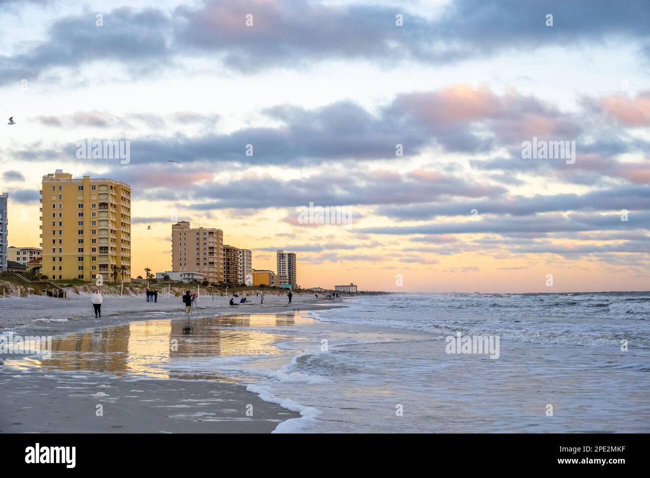 Menschen am Strand von Jacksonville Beach, Florida, genießen die Schönheit und Ruhe eines farbenfrohen Sonnenaufgangs im Meer. (USA) Stockfoto