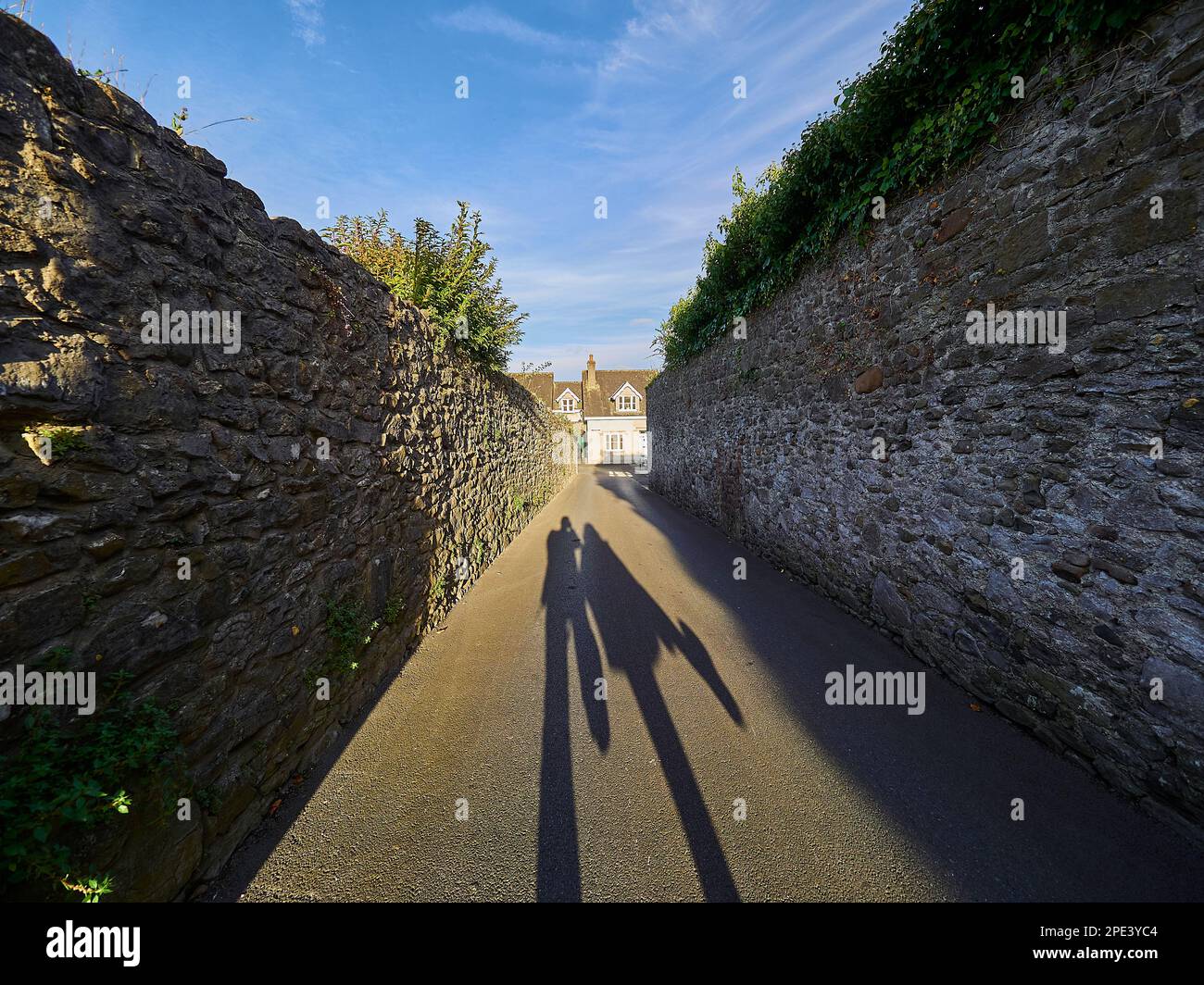 Schatten der Silhouette eines jungen Paares, das in Kilkenny die Straßen entlang geht, Händchen hält und sich küsst. Stockfoto