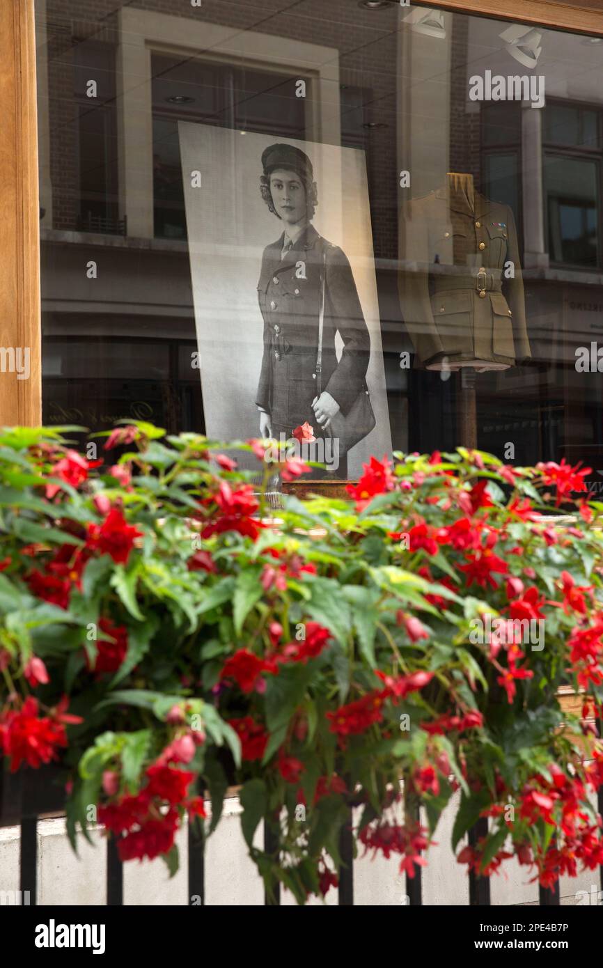 Ein Porträt der verstorbenen Königin Elizabeth II. Wird gesehen, wie sich die Trauernden am Tag ihrer Beerdigung im Zentrum von London versammeln, um ihre Ehre zu erweisen. Stockfoto