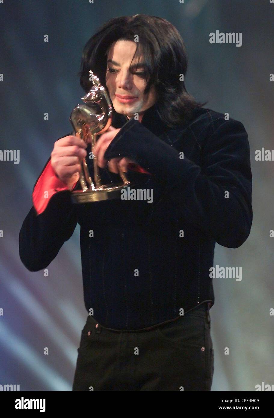U.S Pop Star Michael Jackson looks at his Golden Bambi Award during the Bambi Award Ceremony in Berlin Thursday, Nov. 21, 2002, after he received the German media prize for his life-time achievment. (AP Photo/Roberto Pfeil) Stockfoto