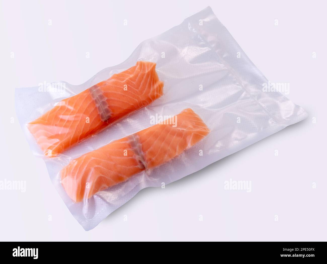 Lachsscheiben in vakuumverpackter Verpackung, versiegelt für Sous-Vide-Kochen auf weißem Hintergrund Stockfoto