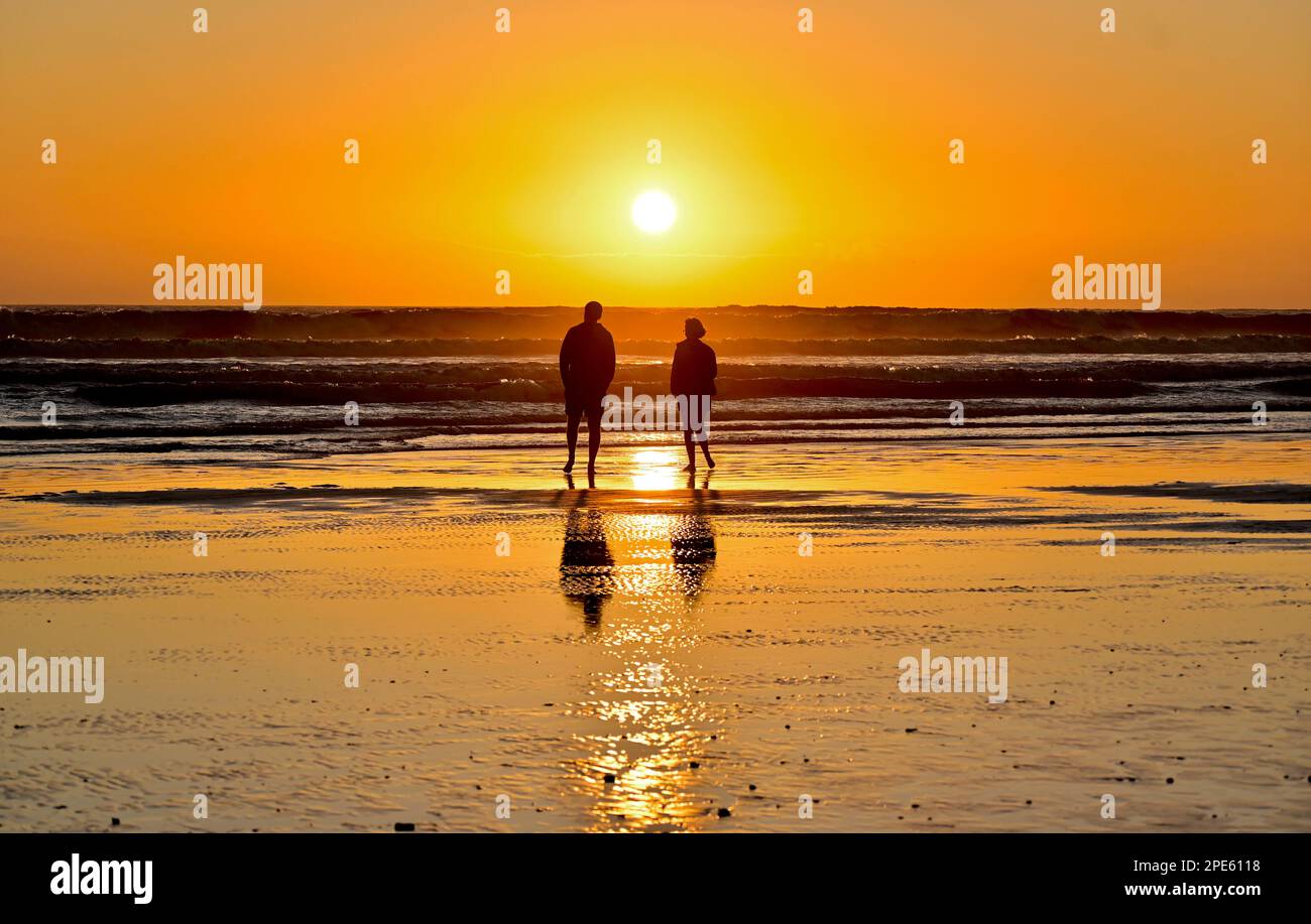 Zwei Personen genießen den Sonnenuntergang im Strand, Western Cape, Südafrika Stockfoto