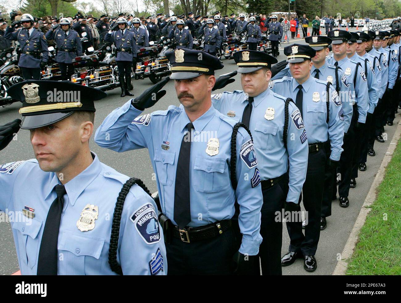 Members of the Minneapolis Police Honor Guard and the St. Paul motorcycle police join thousands of other officers as they stand at attention outside the funeral for St. Paul Sgt. Gerald Vick in St. Paul, Minn., Wednesday, May 11, 2005. Vick, who was working undercover, was killed outside a St. Paul bar Friday, May 6. (AP Photo/Ann Heisenfelt) Stockfoto