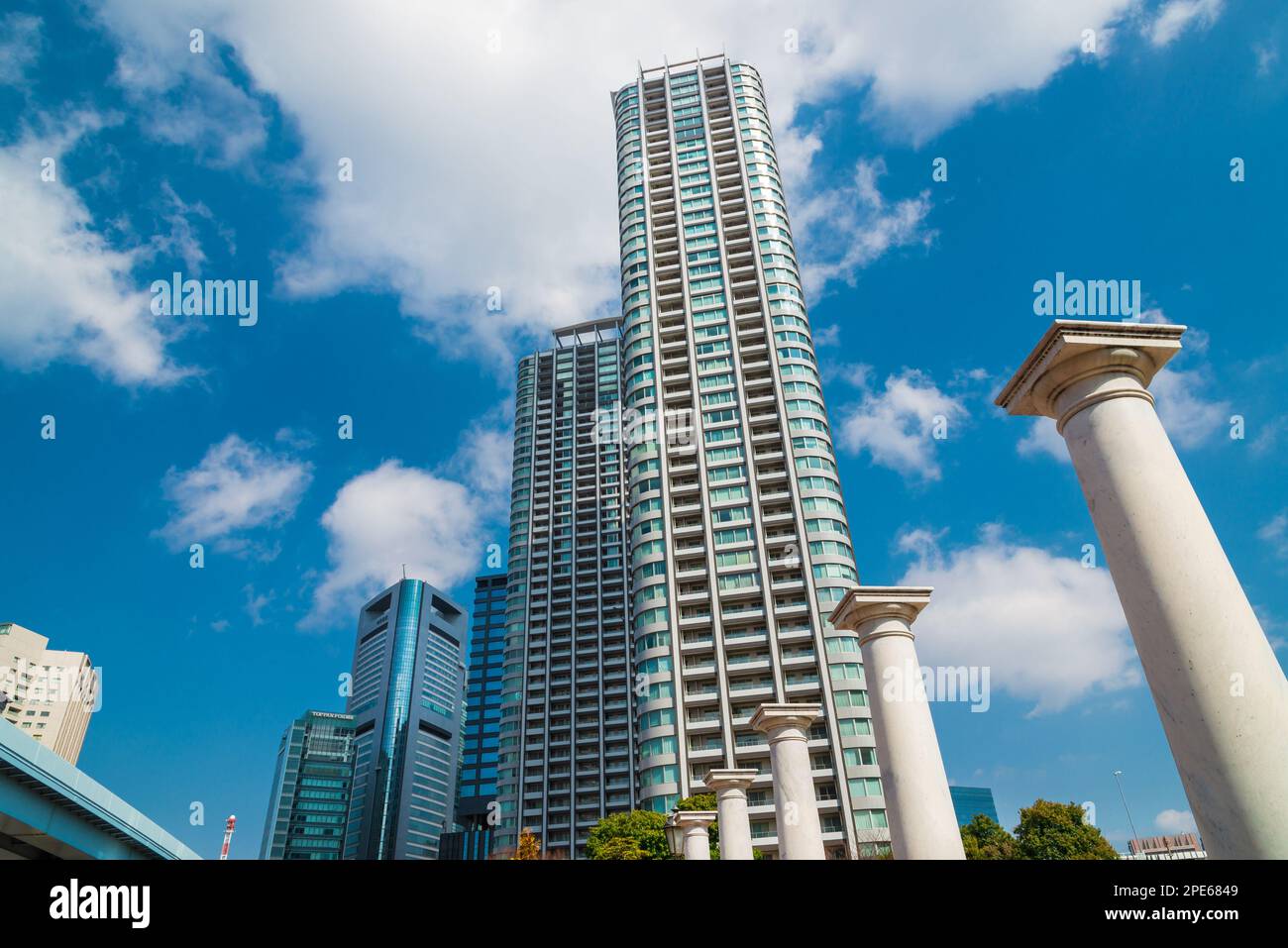Alte und neue Architektur in Tokio. Blick auf die Wolkenkratzer im Viertel Shimbashi mit dorischen Säulen vom öffentlichen Park „Parco Italia“ Stockfoto