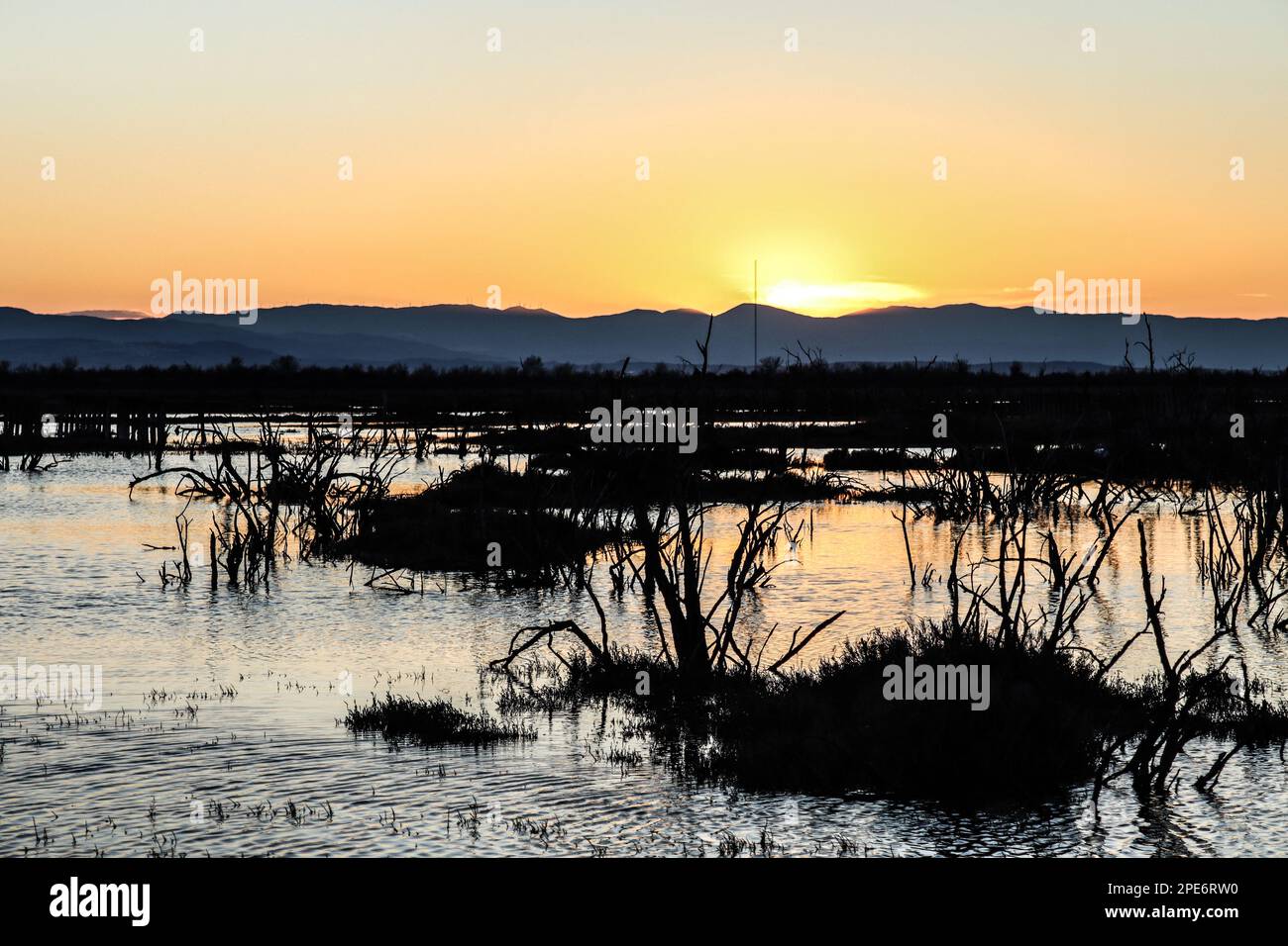 blick auf den fluss delta mit einer Bergkette im Hintergrund bei Sonnenuntergang Stockfoto