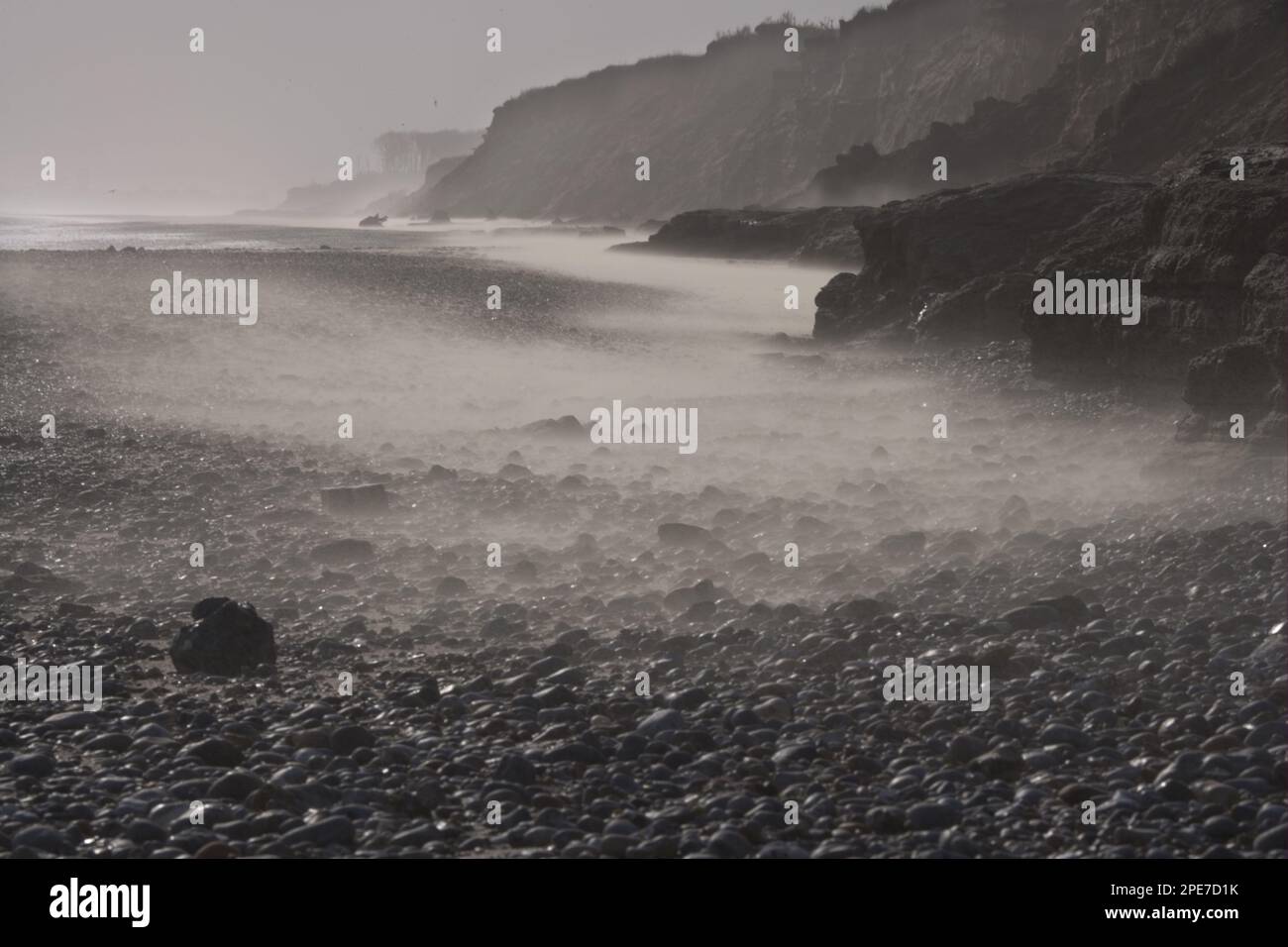 Windgepeitschter Sand am Strand, mit Kieselsteinen teilweise mit Sand bedeckt, verfallene Klippen im Hintergrund, Covehithe, Suffolk, England, Vereinigtes Königreich Stockfoto