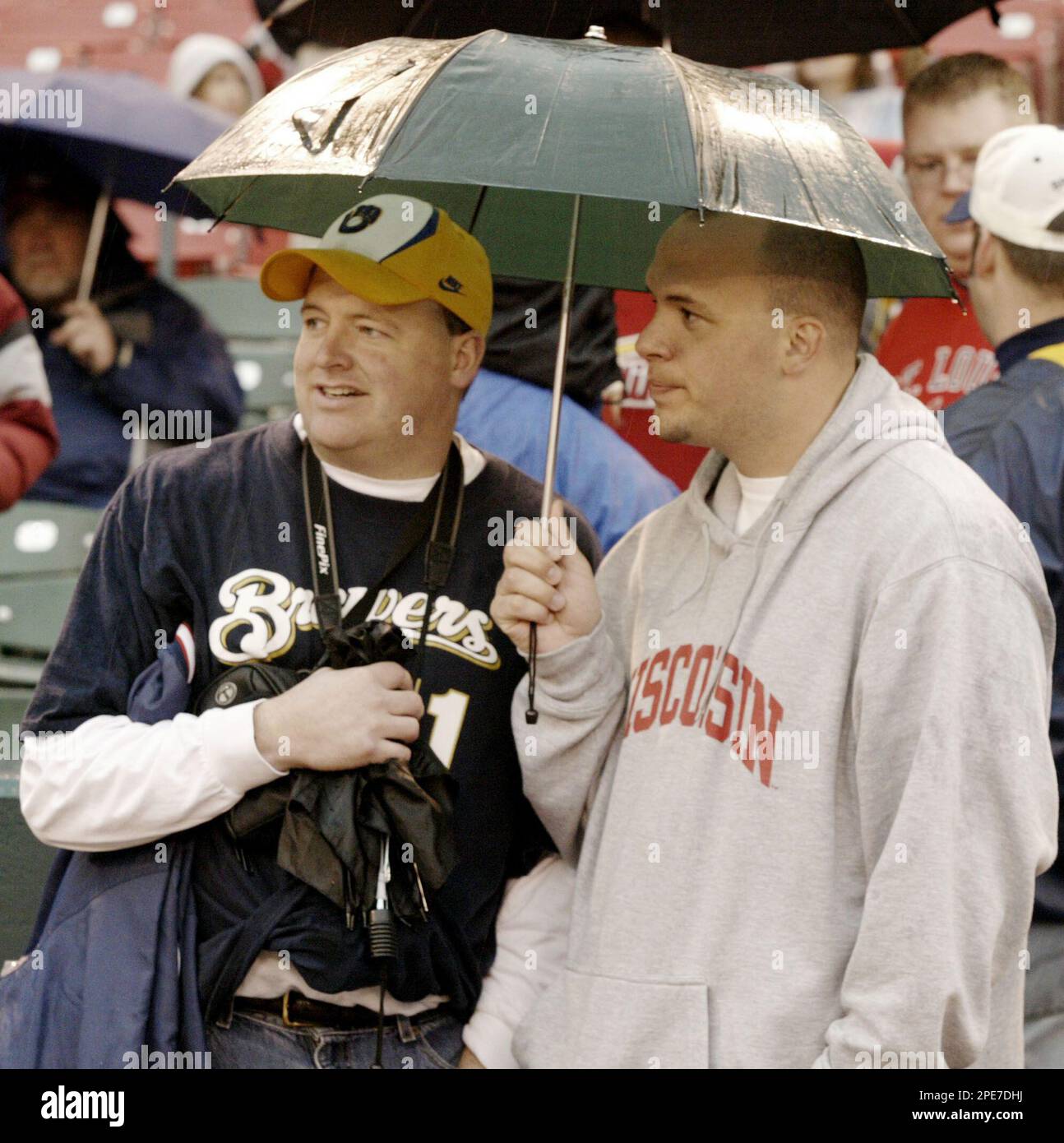 Mark Zaves, left, of Appleton, Wis., and his brother, Dan Zaves, from Colorado Springs, Colo. stand in the rain while waiting for word on the start of Milwaukee Brewers-St. Louis Cardinals game in St. Louis Monday, April 25, 2005. The game was postponed because of rain and has been rescheduled for Thursday, April 28. (AP Photo/James A. Finley Stockfoto