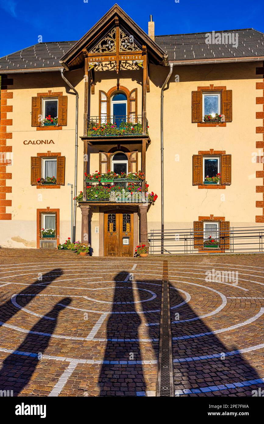 Kreisförmiges Pflaster, dahinter ein älteres Haus im Ladin-Stil, mit Balkonen dekoriert mit Blumen, Sankt Christina, Val Gardena, Dolomiten, Süden Stockfoto