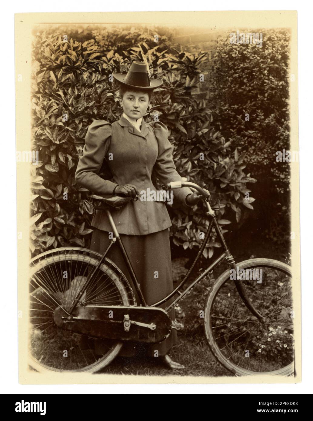 Original viktorianisches Foto einer jungen viktorianischen Radfahrerin mit ihrem Fahrrad in einem Garten, um 1898, Worcester Area, Großbritannien Stockfoto