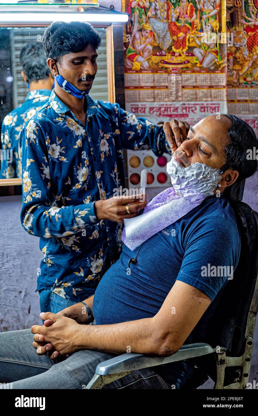 Friseur rasiert einen Mann im Friseur in Chandni Chowk, Old Delhi Stockfoto