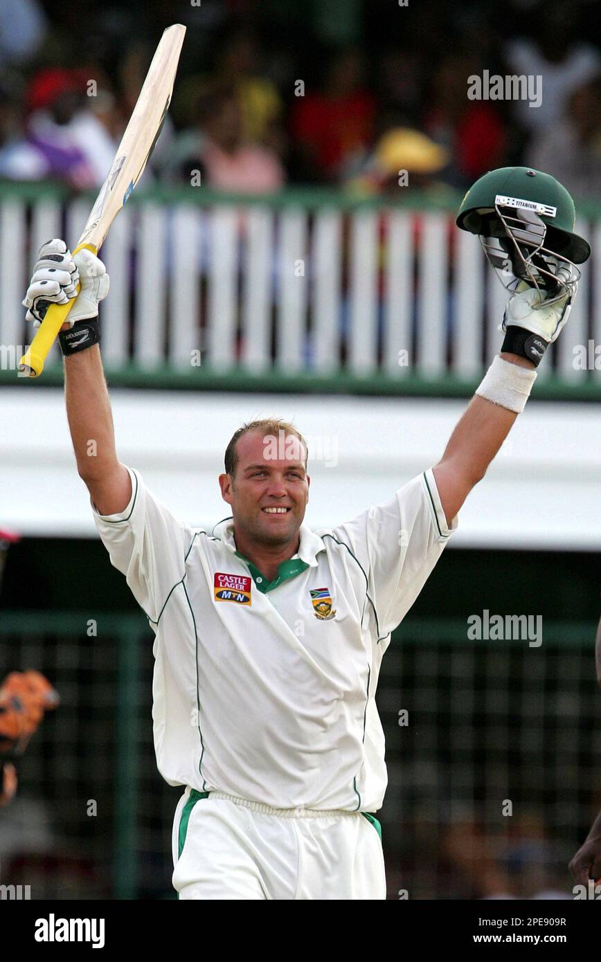 South Africa's batsman Jacques Kallis raises his bat and helmet after scoring a century during their follow-on second innings on the final day of the first test match against the West Indies at Bourda, Georgetown, Guyana, Monday, April 4, 2005. Kallis passed 7,000 test runs, becoming only the second South African after Gary Kirsten to achieve that mark. (AP Photo/Andres Leighton) **EFE OUT** Stockfoto