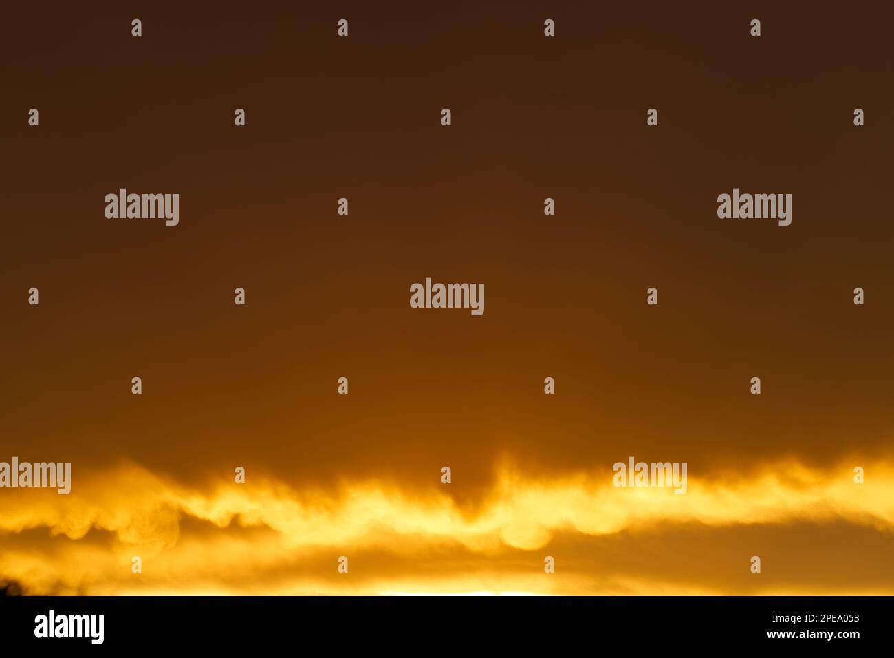 Orangefarbener Hintergrund mit Wolken und Sonnenlicht am späten Nachmittag, Victoria, Australien. Stockfoto