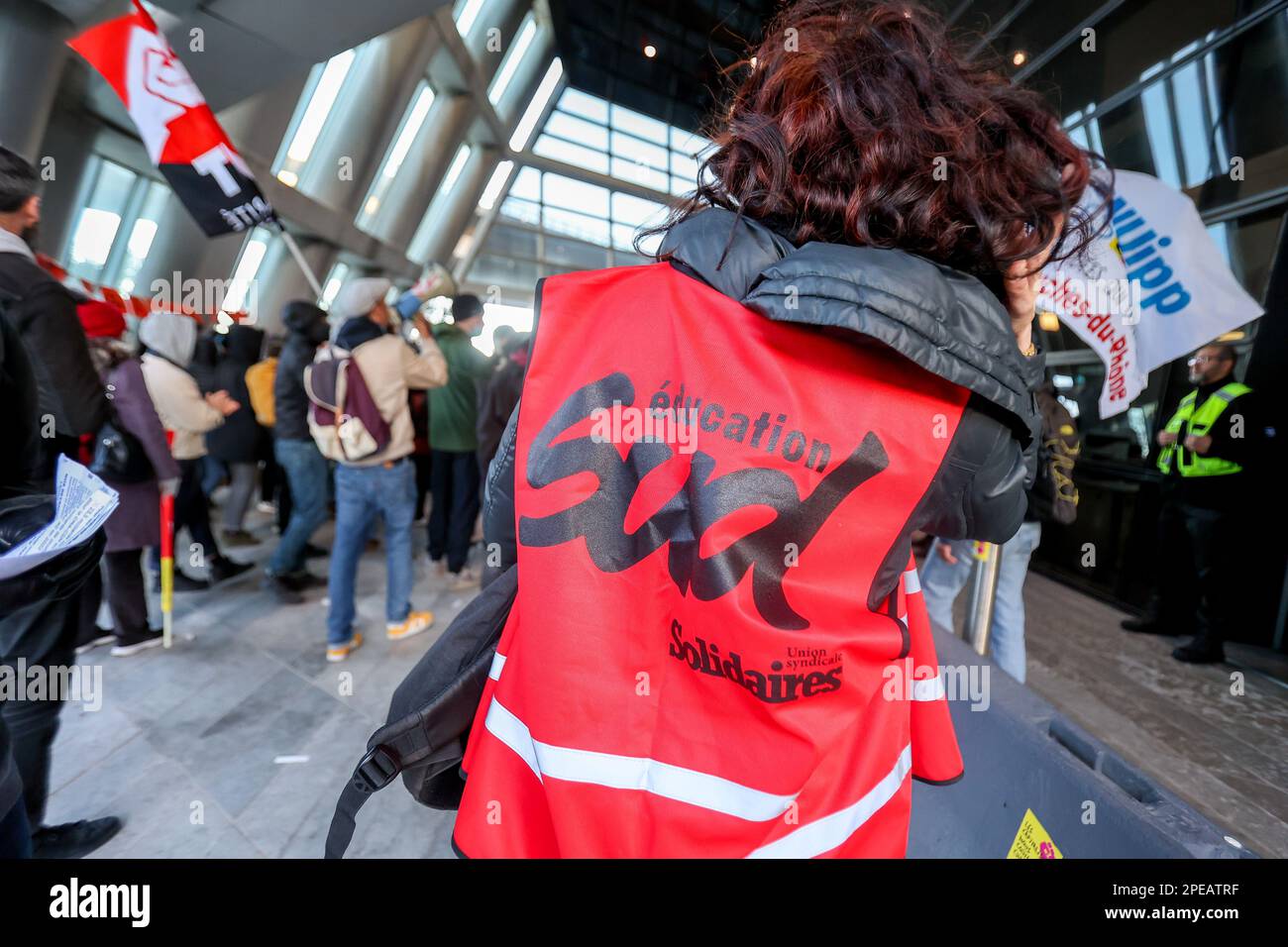 Marseille, Frankreich. 15. März 2023. Ein Protestteilnehmer der Sud-Gewerkschaft trägt eine Weste mit der Aufschrift Sud Education, die den Eingang zum CMA-CGM-Turm in Marseille blockiert. Hunderte von Demonstranten blockierten den Eingang zum CMA CGM-Turm in Marseille. Sie verurteilen die Überschüsse des Reeders, dessen Gewinne im Jahr 2022 explosionsartig gestiegen sind, nämlich über 23 Milliarden Euro. (Foto: Denis Thaust/SOPA Images/Sipa USA) Guthaben: SIPA USA/Alamy Live News Stockfoto