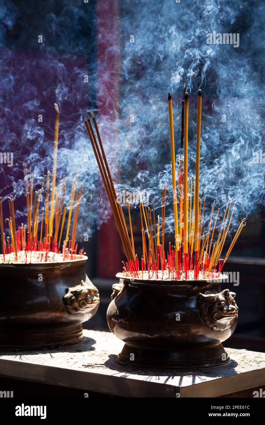 Viele duftende Räucherstäbchen brennen in einem buddhistischen Tempel und schaffen eine duftende und rauchige Atmosphäre. Die Rauchwirbel in der Luft tragen zum heiligen und bei Stockfoto