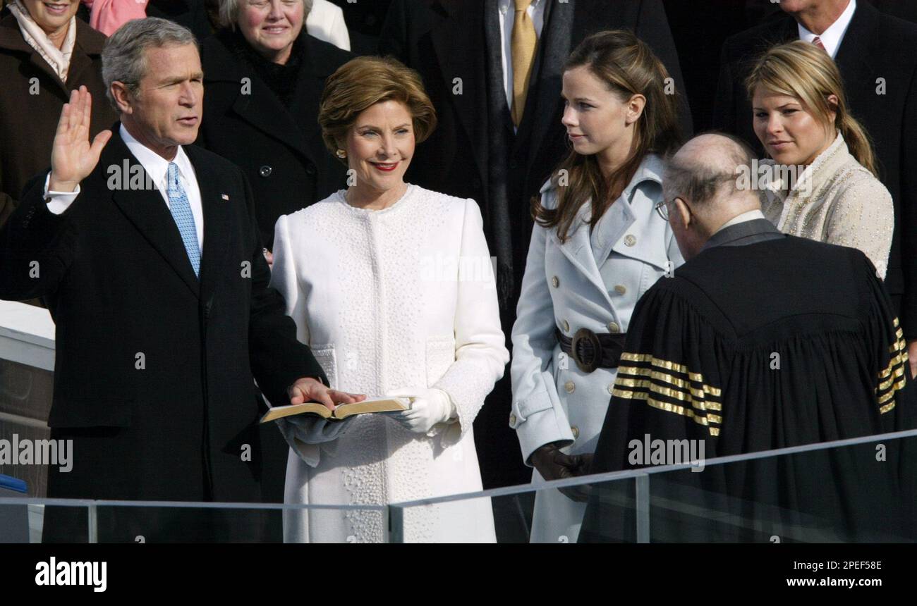 ** RETRANSMITTED FOR ALTERNATE CROP ** President Bush takes the oath of office from Chief Justice William Rehnquist, right, with first lady Laura Bush, and his daughters Barbara and Jenna at his side at the US Capitol in Washington, Jan. 20, 2005. In background are Speaker of the House Dennis Hastert, left, and Sen. Trent Lott, R-Miss. (AP Photo/Paul Sancya) Stockfoto