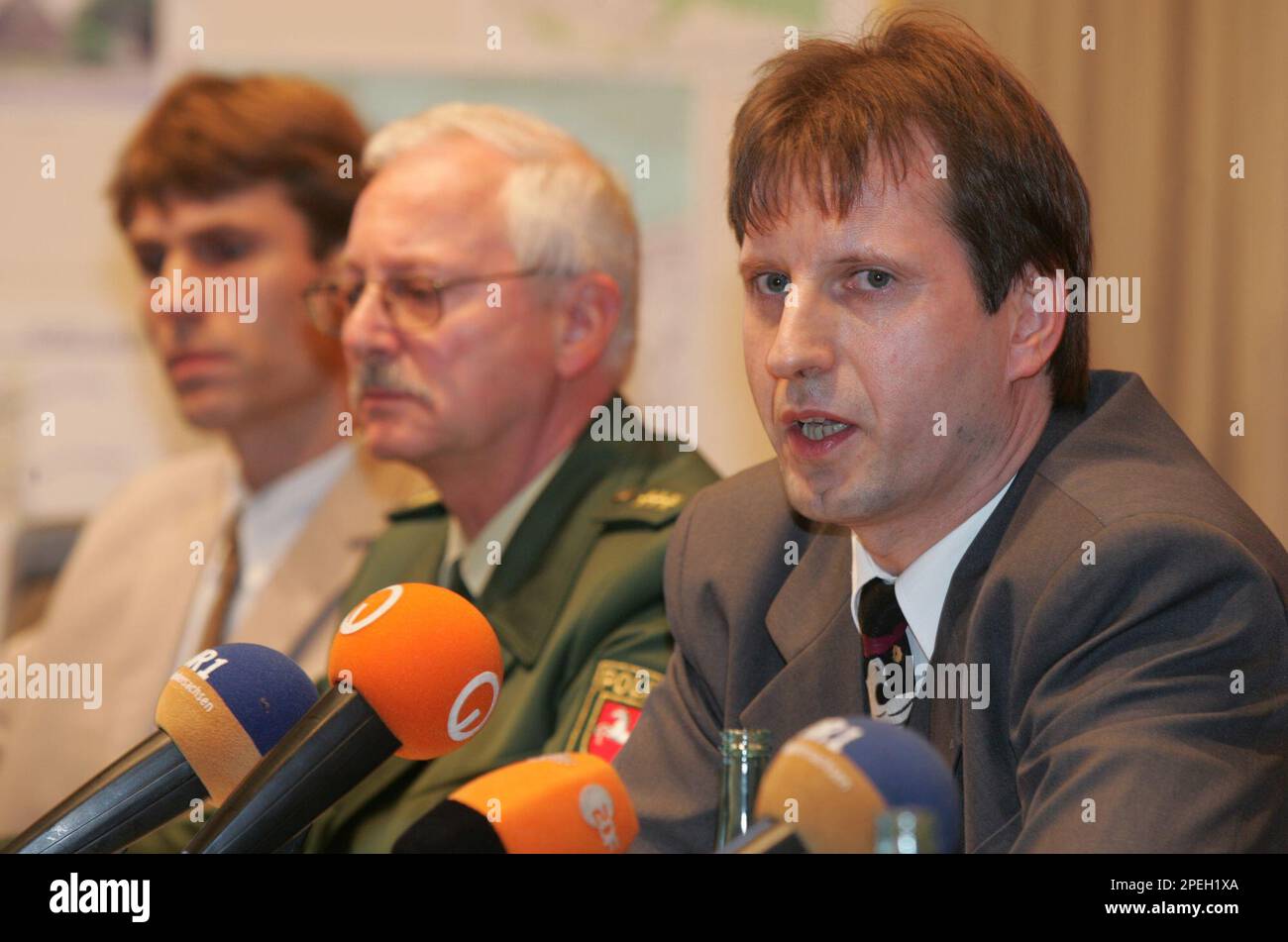 Der Leiter der "SoKo Levke" Karsten Bettels, rechts, gibt am Donnerstag, 9. Dezember 2004, waehrend einer Pressekonferenz in Cuxhaven die Verhaftung des mutmasslichen Moerders von Levke Strassheim bekannt. Das achtjaehrige Maedchen verschwand im 6. Mai 2004. Ihre Leiche wurde spaeter in einem Wald bei Attendorn im Sauerland gefunden. Links sitzt Oberstaatsanwalt Burkhard Vonnahme, in der Mitte der Leiter der Polizeiinspektion Cuxhaven Friedhold Schacht.(AP Photo/Joerg Sarbach) Stockfoto