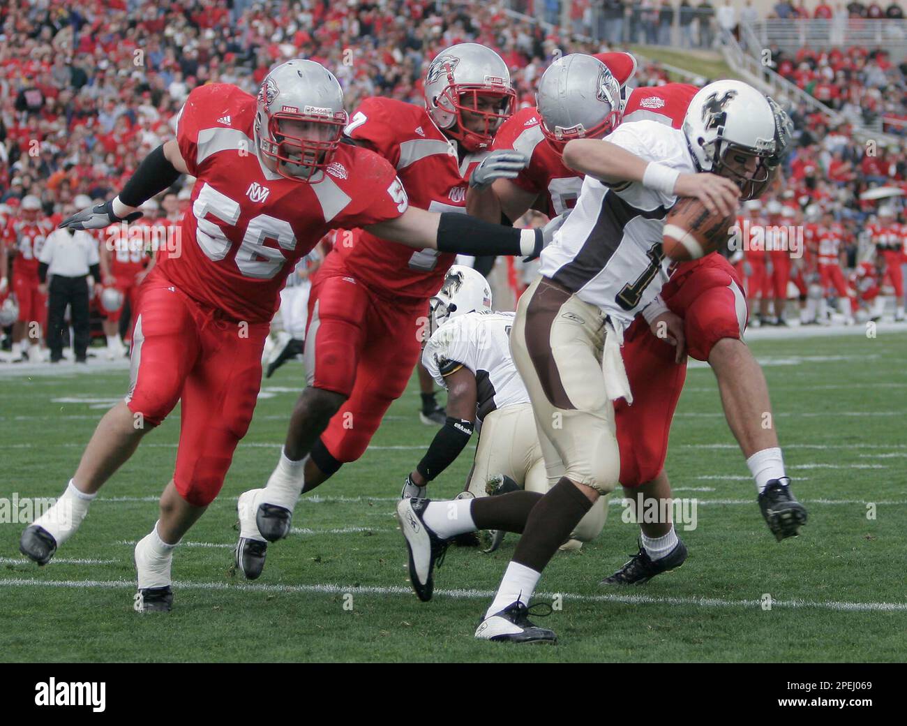 New Mexico's Mike Mohoric (56), Charles Brown (7) and Nick Speegle, center right, chase down and sack Wyoming quarterback Corey Bramlet in the end zone for a safety during the first quarter at University Stadium in Albuquerque, N.M., Saturday, Nov. 20, 2004. (AP Photo/Jake Schoellkopf) Stockfoto