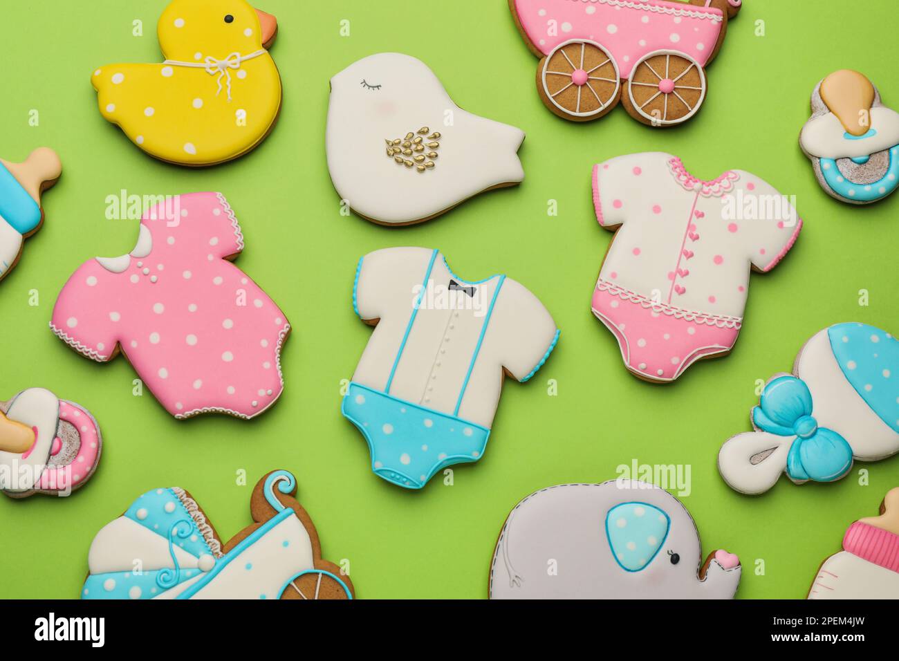 Süße leckere Kekse in verschiedenen Formen auf hellgrünem Hintergrund, flach liegend. Babyparty Stockfoto