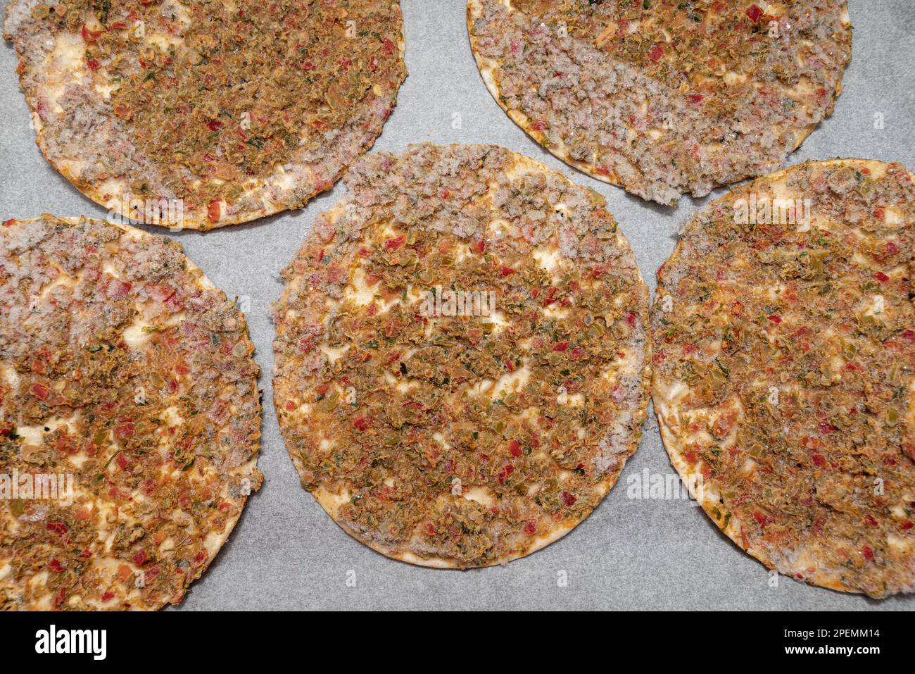Verzehrfertiger gefrorener Lahmacun auf Backpapier auf einem Backblech Stockfoto