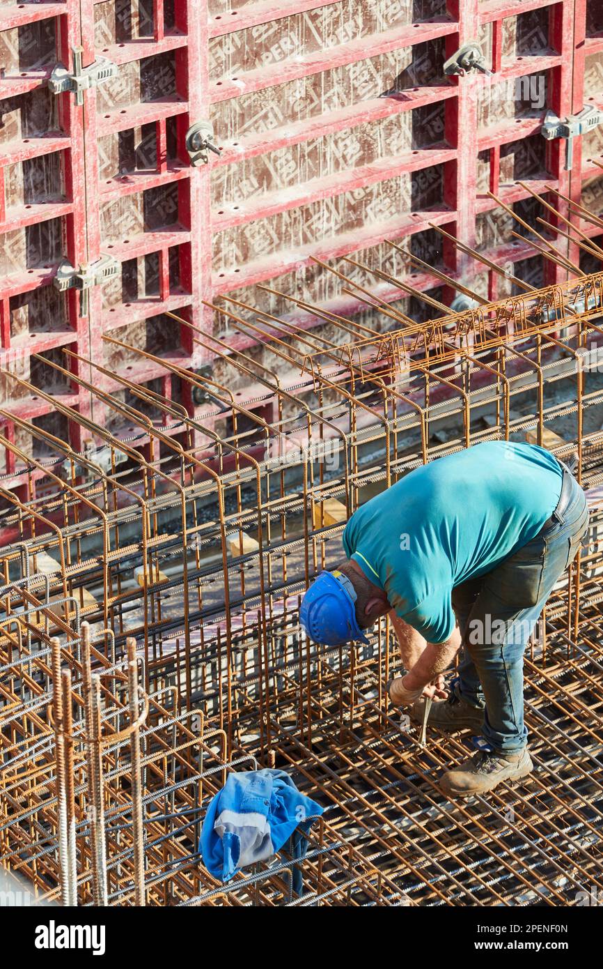 Arbeiter verbindet Stahlverstärkung auf Betonbaustelle Stockfoto