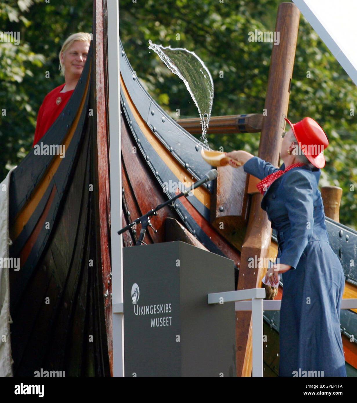 Queen Margrethe of Denmark christens a replica of a 1,000-year-old Viking sailing vessel Saturday Sept. 4, 2004 in Roskilde, Denmark. Plans are for a crew of 60 men to sail the vessel, which builders say is the world's longest Viking ship reconstruction, to Britain and Ireland in 2007 along the routes once used by marauding Norsemen. (AP Photo/John McConnico) Stockfoto