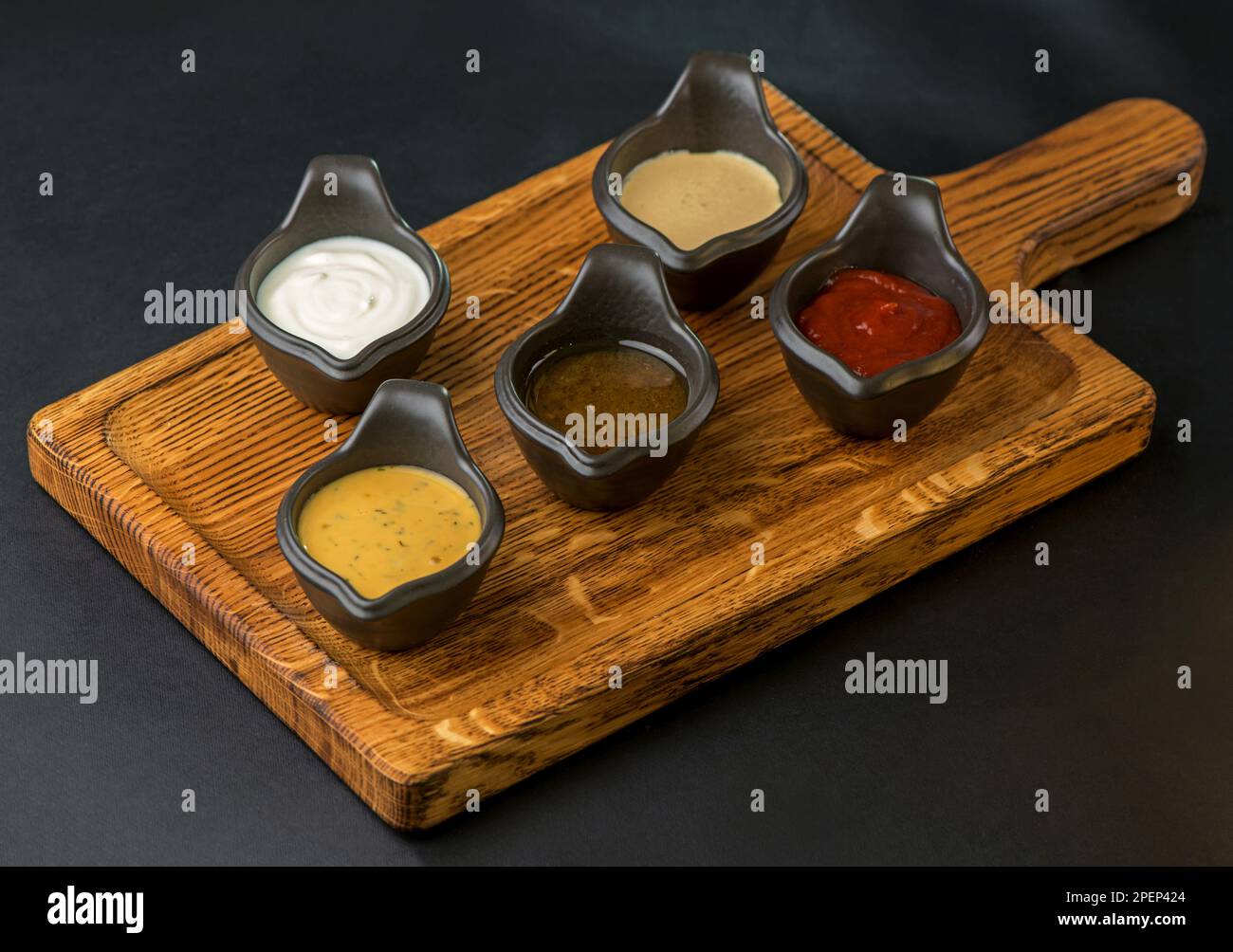 Verschiedene Saucen auf schwarzem Hintergrund Stockfoto