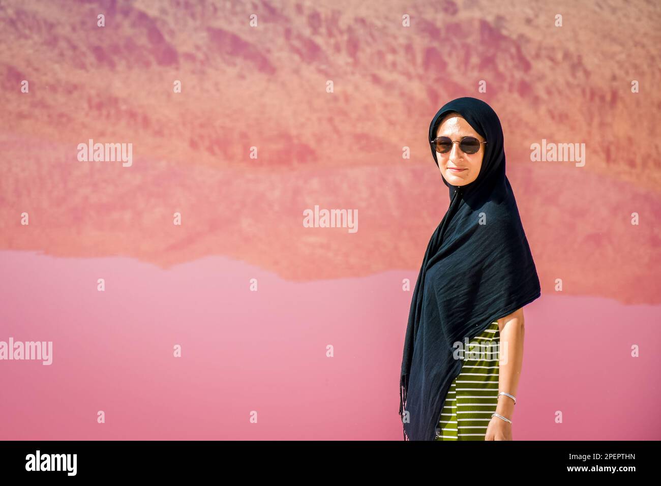 Weißer Touristenstand am rosa Salzsee von Maharlu mit Reflexionen. Reiseziel Iran in Shiraz Stockfoto