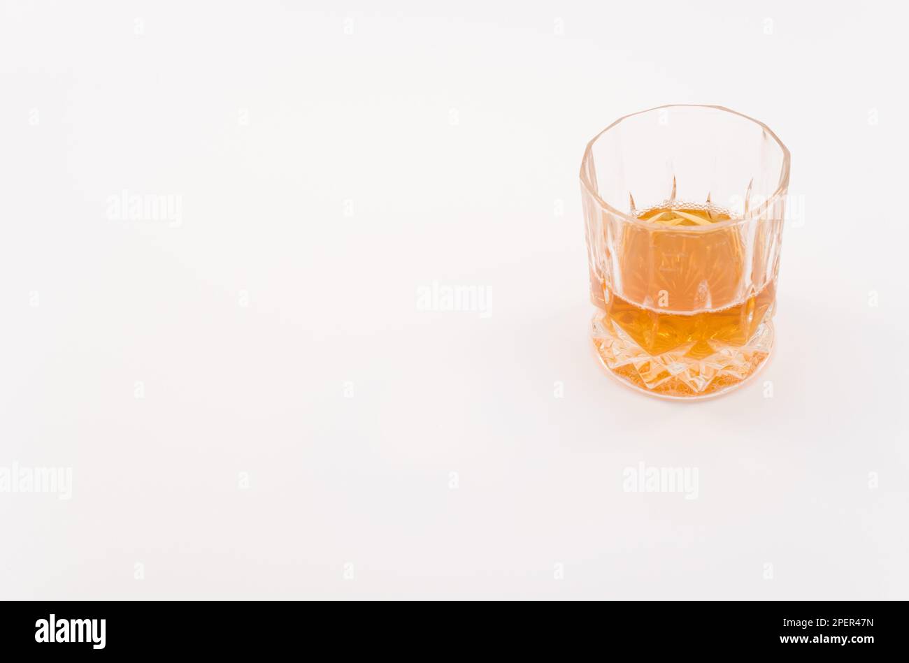 Glas mit alkoholischem Getränk isoliert auf einer weißen Tischoberfläche Stockfoto