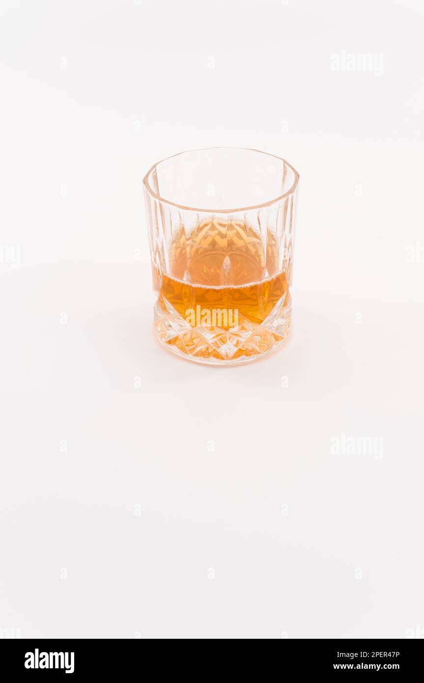 Glas mit alkoholischem Getränk isoliert auf einer weißen Tischoberfläche Stockfoto