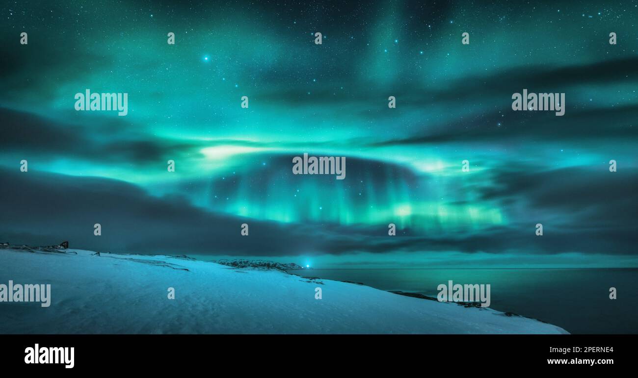 Aurora Borealis über dem Ozean. Nordlichter und gefrorene Seeküste Stockfoto