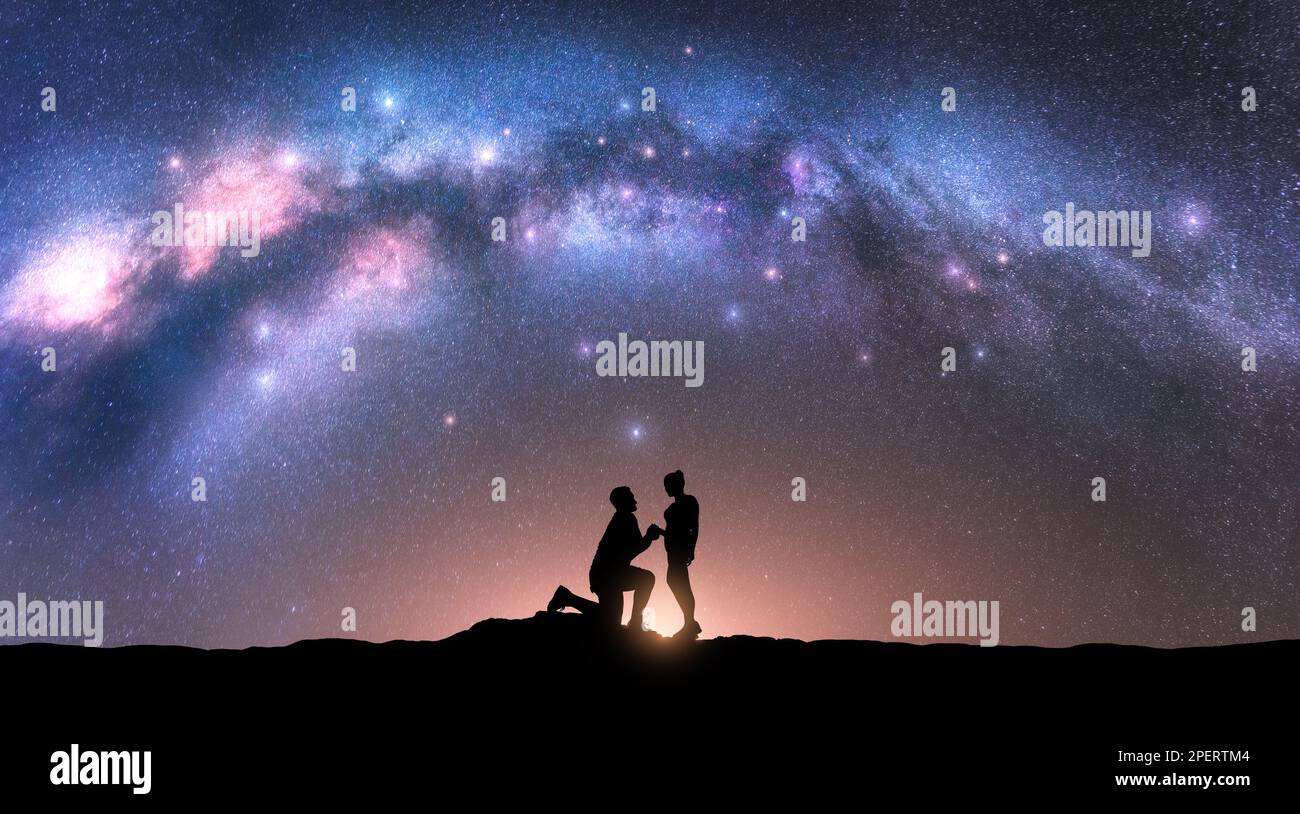Milchstraße mit Silhouetten von Liebenden und Sternenhimmel bei Nacht Stockfoto
