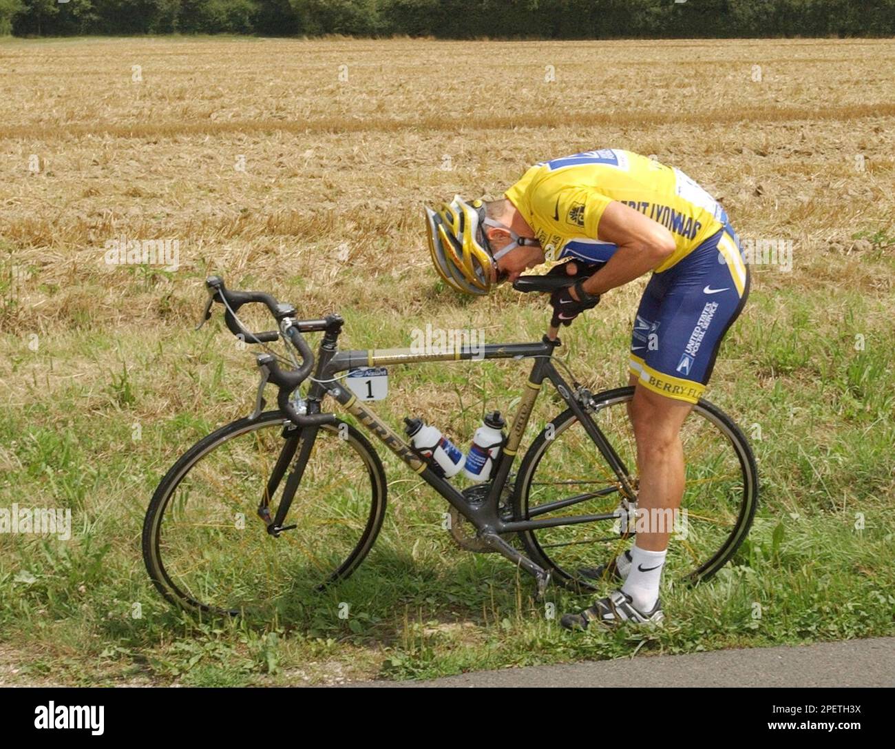 Overall leader and five time Tour de France winner lance Armstrong of Austin Texas stops by the side of the road to adjust the saddle of his brand new bicycle decorated with golden