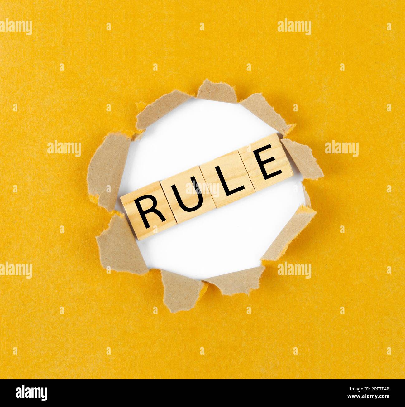 Textumbruch die Regeln, die hinter geripptem gelben Papier angezeigt werden. Stockfoto