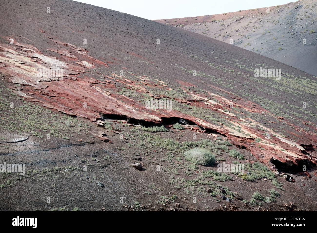 Rotes Aschepikon und Erde, die sich durch den parque nacional de timanfaya Lanzarote, Kanarische Inseln, Spanien, durchbrechen Stockfoto